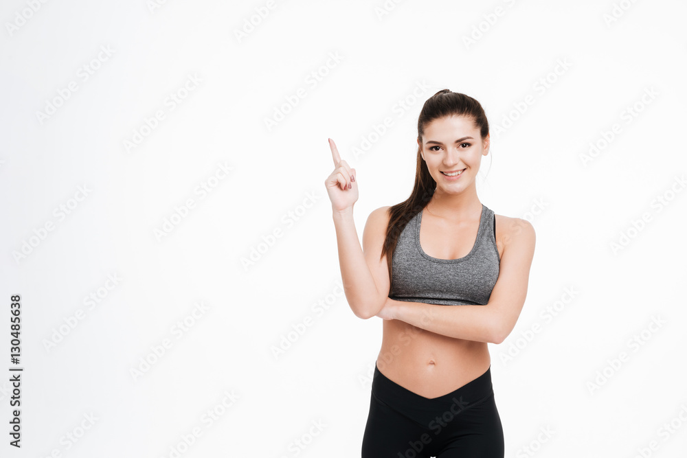 Portrait of a happy fitness woman pointing finger up Portrait of a happy fitness woman pointing finger up