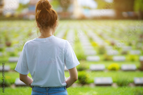 Teen girl standing memorial grave...