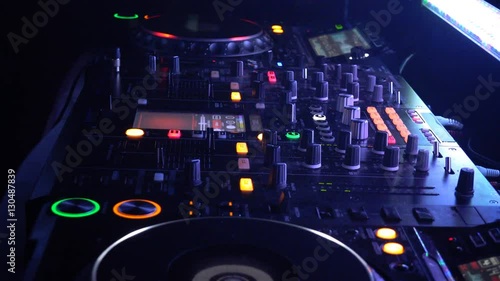 DJ behind the decks in a nightclub. DJ spinning plate. people dancing in a nightclub.