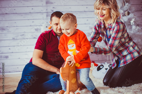 The father,mother and son sitting near Christmas Tree photo