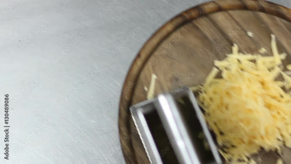 chef take off grating yellow cheese with metal grater from table chef take off grating yellow cheese with metal grater from table