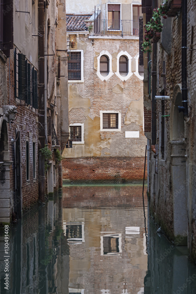 Venetian house reflects in calm canal water Venetian house reflects in calm canal water