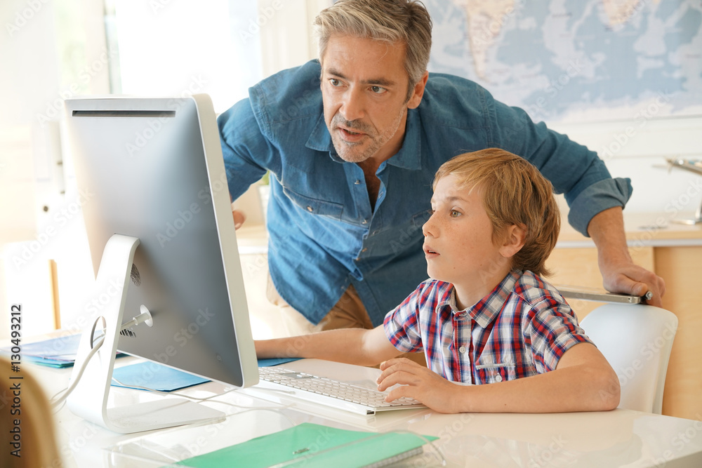 Schoolboy in computer lab with teacher helping Schoolboy in computer lab with teacher helping