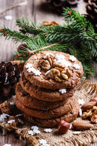 Christmas chocolate cookies with nuts, fir branches, pine cones