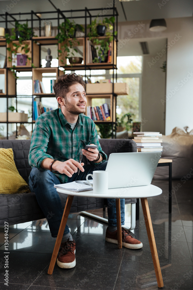 Vertical image of handsome man writing something Vertical image of handsome man writing something