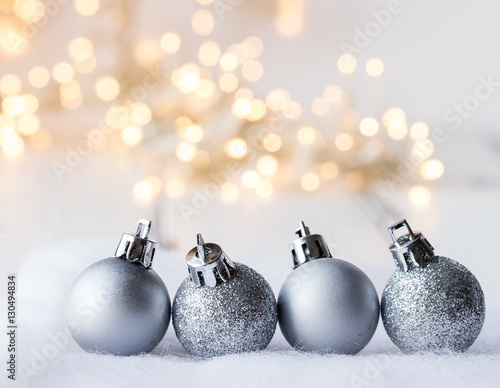 julgrans kulor i silver i förgrunden belysning ofokuserat i bakgrunden med utrmme för egen text