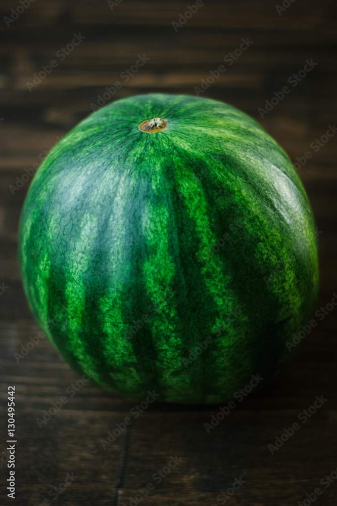 Watermelon. Whole undivided fresh green watermelon on brown wooden board Watermelon. Whole undivided fresh green watermelon on brown wooden board