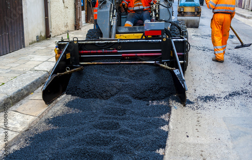 lightl truck laying fresh bitumen and asphalt at road construction site photo