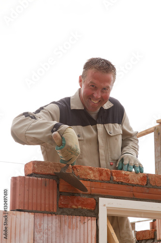 Wallpaper Mural smiling bricklayer mason takes away the cement with trowel Torontodigital.ca