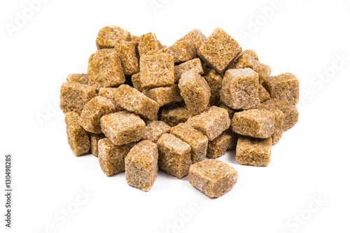 Pile of pieces of unrefined brown sugar isolated on white background