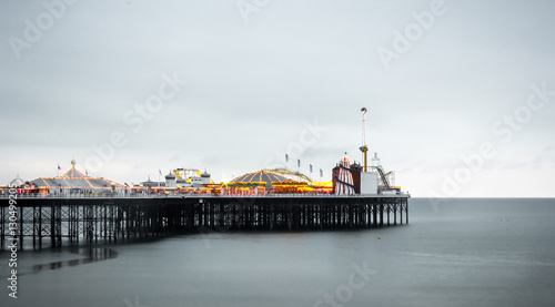 Long exposure of Brighton Pier from beach during cloudy/overcast day photo