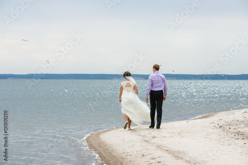 the bride and groom are on the seashore