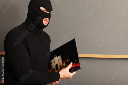 Maskierter Mann beim Bilder klauen photo