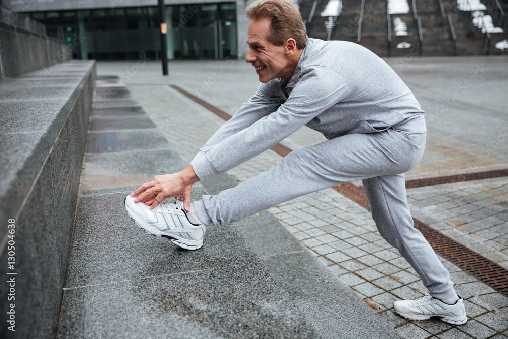 Fototapeta premium Runner warming up on the street