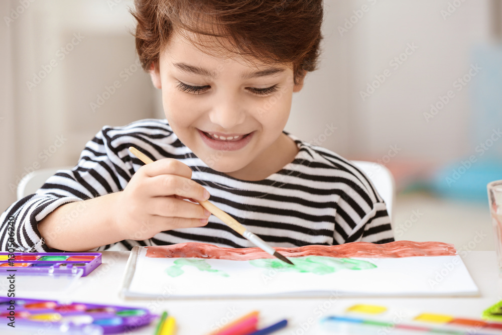 Cute little boy painting, on blurred background Cute little boy painting, on blurred background