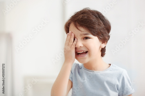 Cute emotional little boy on light blurred background