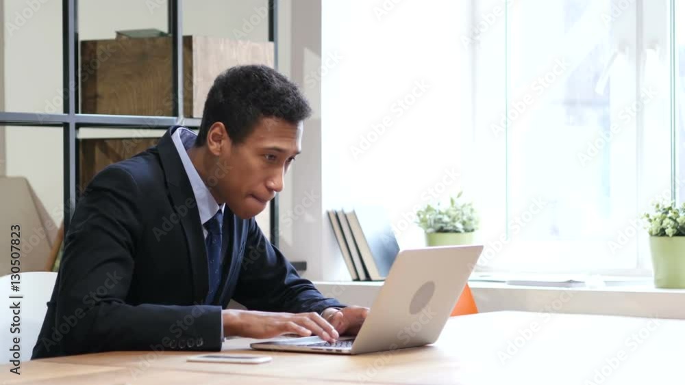 Black Businessman Celebrating Success while Working on Laptop Black Businessman Celebrating Success while Working on Laptop