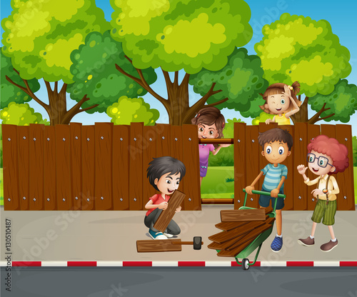 Many children fixing wooden fence together
