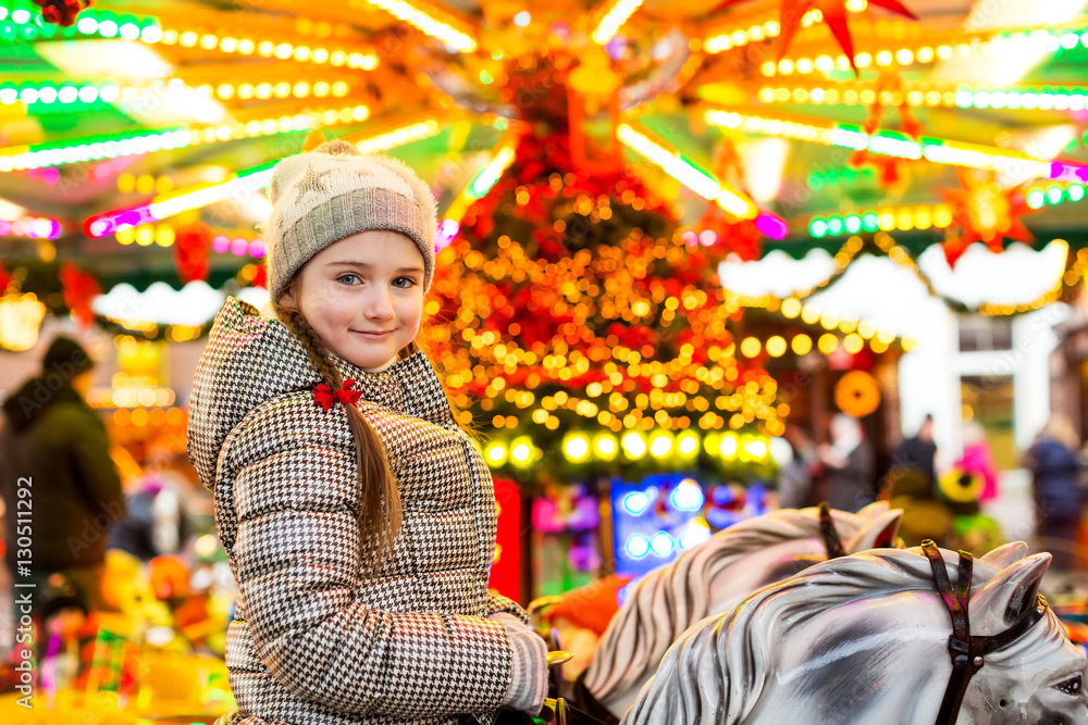 Portrait of a happy little girl riding on horses on carousel, tr Portrait of a happy little girl riding on horses on carousel, tr