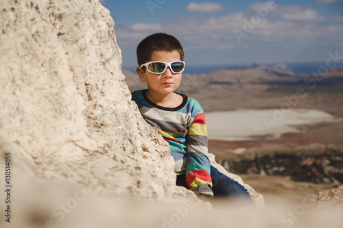boy in sunglasses sits on the top