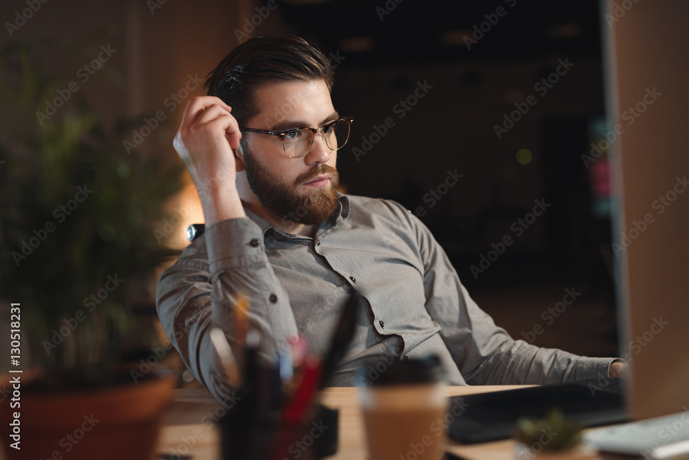 Concentrated bearded designer working on computer.