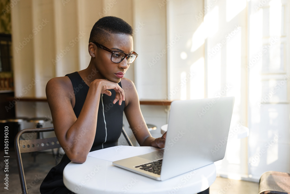 Young fashionable african business woman working hard at the cafe on the laptop Young fashionable african business woman working hard at the cafe on the laptop