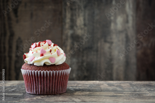 Valentine cupcake decorated with sweet hearts on wooden table
