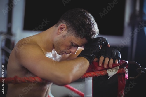 Boxer leaning on boxing ring