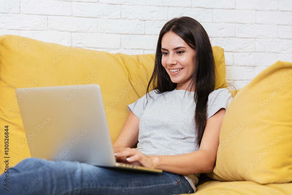 Girl sitting on sofa with laptop Girl sitting on sofa with laptop