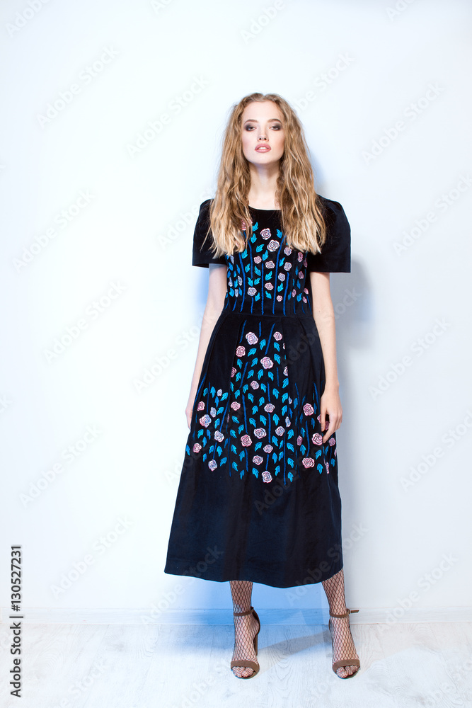 Beautiful curly girl in fashionable dress posing in the studio Beautiful curly girl in fashionable dress posing in the studio