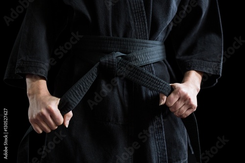 Confident karate player holding his belt