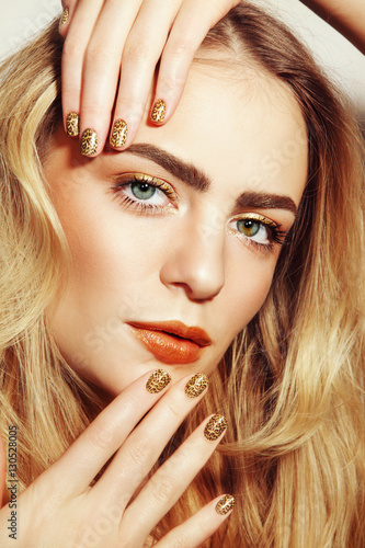 Portrait of young beautiful girl with golden make-up and fancy wild manicure