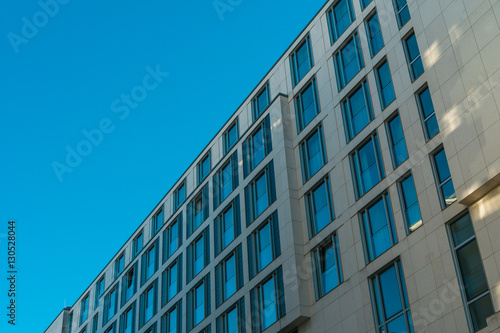 orange colored facade with blue windows and blue sky