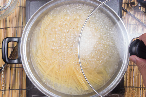 Spaghetti boiling in pan on electric stove