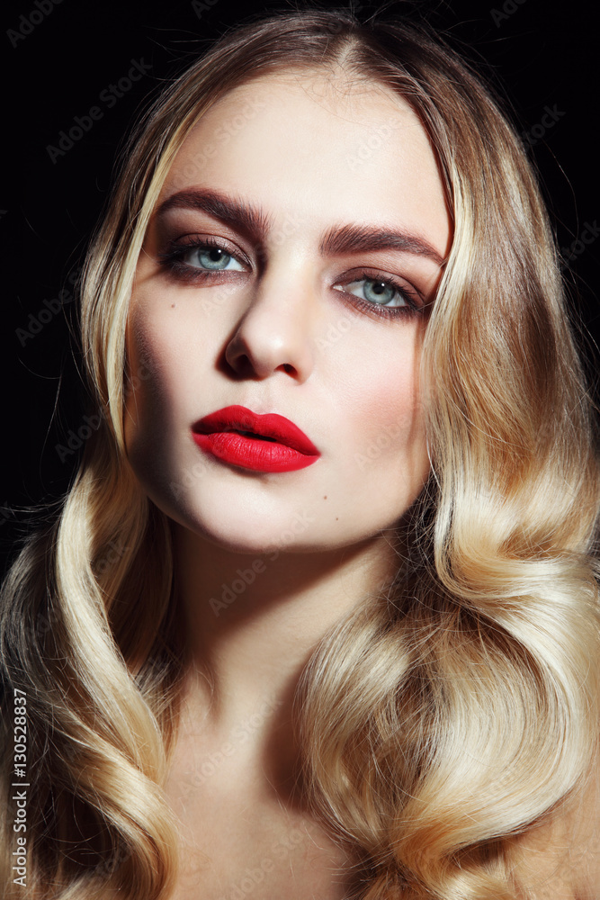 Fototapeta premium Portrait of young beautiful glamorous woman with red lipstick and blonde curly hair