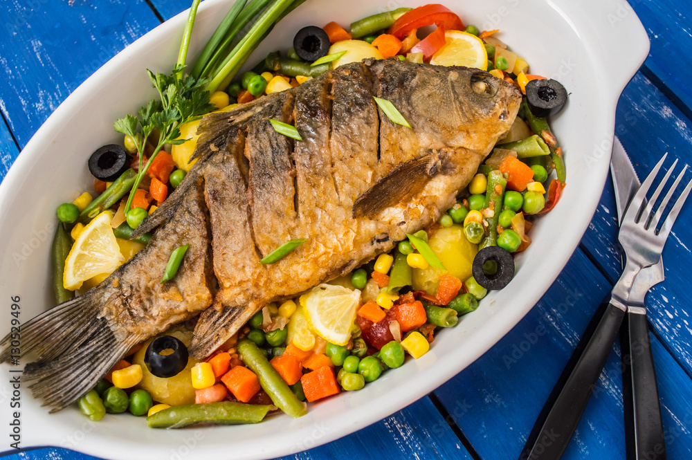 Grilled fish on brown plate with herbs and lemon old wooden background, top view. Mediterranean luxurious seafood concept. Grilled fish on brown plate with herbs and lemon old wooden background, top view. Mediterranean luxurious seafood concept.