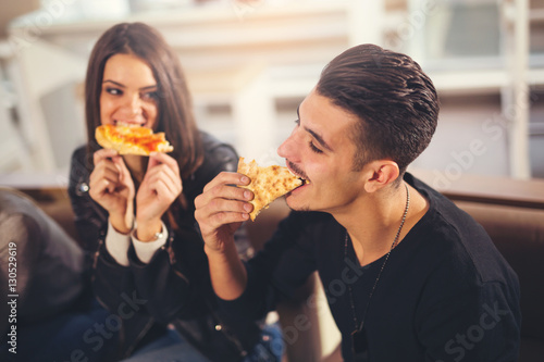 Young people in casual clothes eating pizza