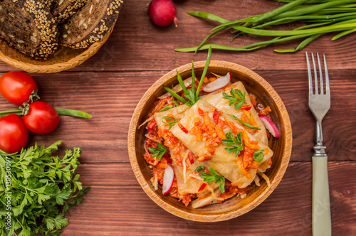 Cabbage rolls in tomato sauce in a bowl. wood background. Top view