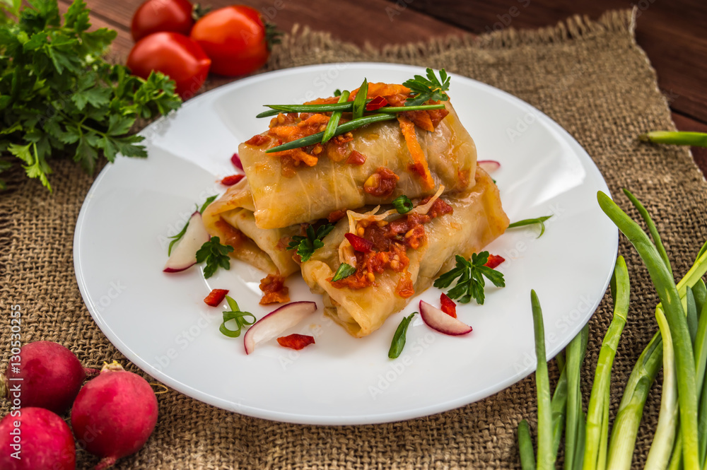 Cabbage rolls in tomato sauce. white plate. wood background. Cabbage rolls in tomato sauce. white plate. wood background.