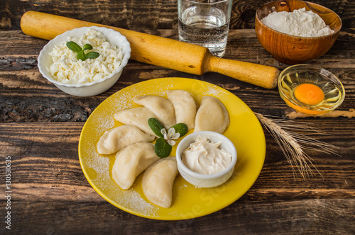 Boiled dumplings with cheese for breakfast. Wooden table. Top view photo