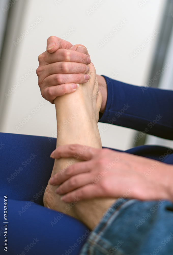 Woman doing foot massage to man at home.