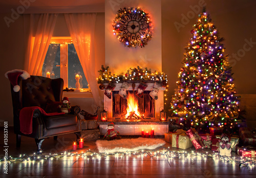 Weihnachtsabend am Kamin in festlich geschmückten Wohnzimmer photo