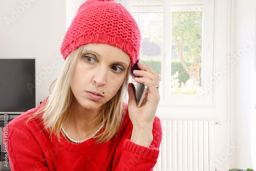 Beautiful young blonde woman with a red cap, phone