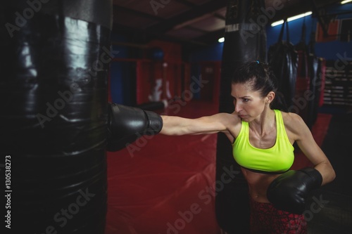 Female boxer practicing boxing with punching bag © WavebreakMediaMicro