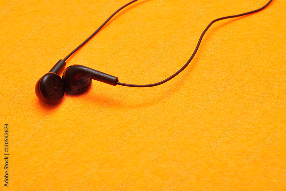 Earphones isolated against a yellow background Earphones isolated against a yellow background
