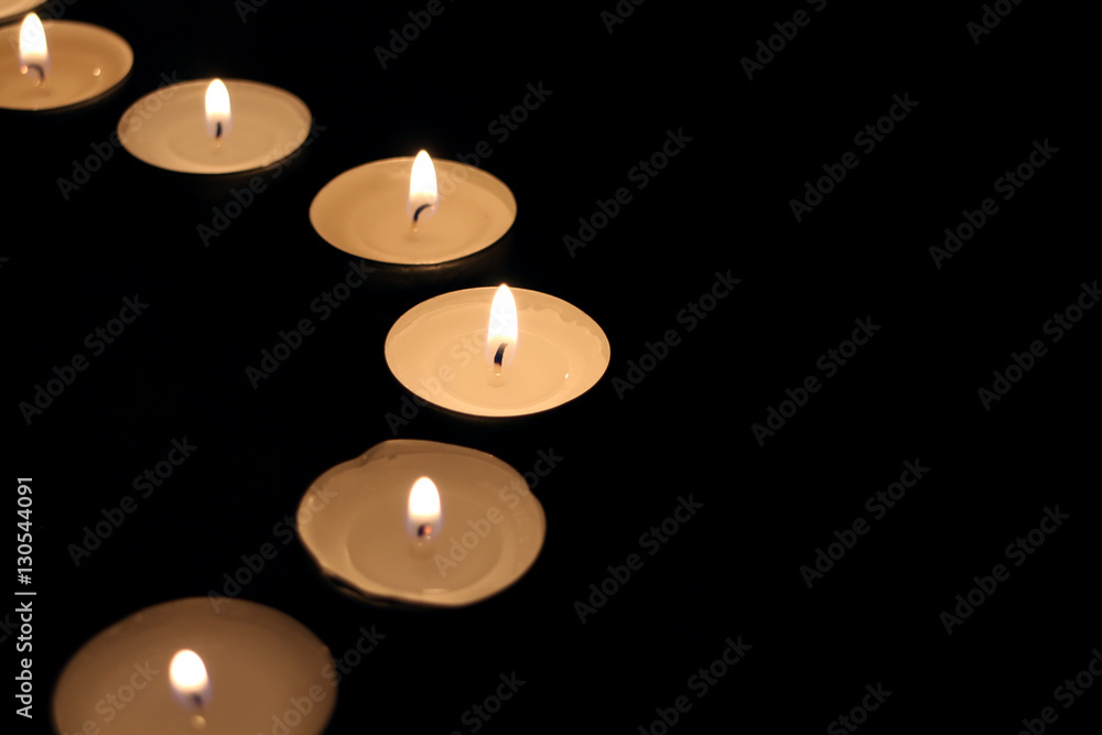 Small candles in the dark in the shape of semicircle Small candles in the dark in the shape of semicircle