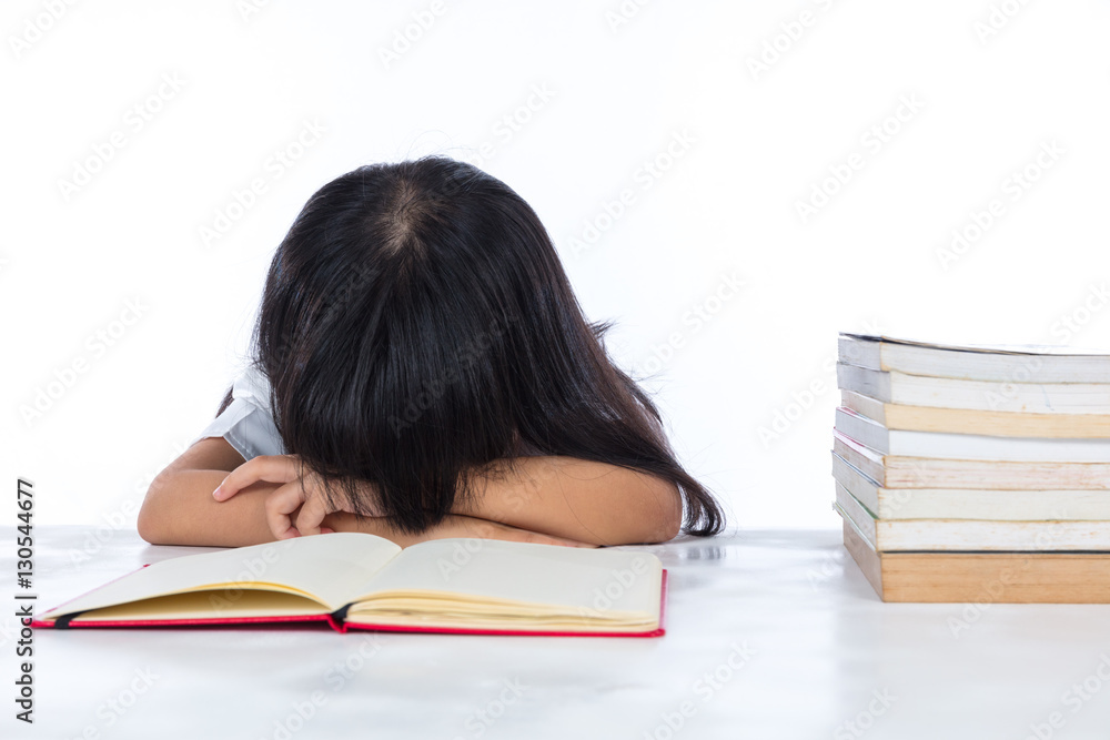 Tired Asian Chinese little girl lying on desk with books Tired Asian Chinese little girl lying on desk with books