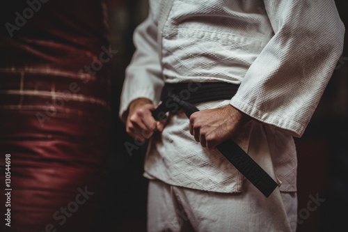 Mid section of karate player tying his belt