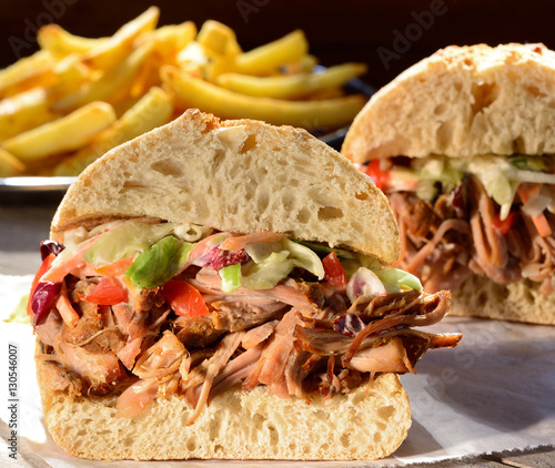 Pulled pork sandwich with coleslaw salad and fries.