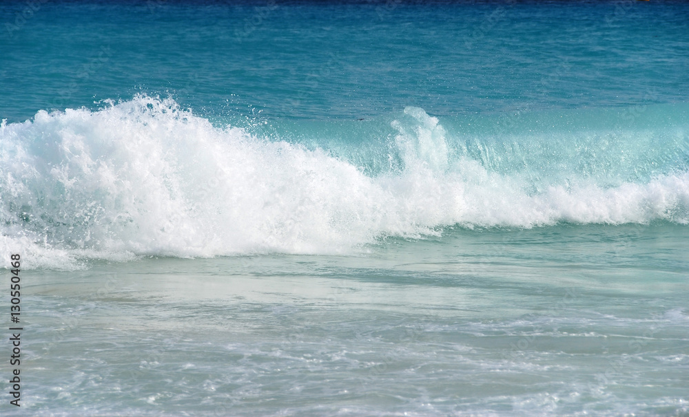 blue ocean wave splashing on shore